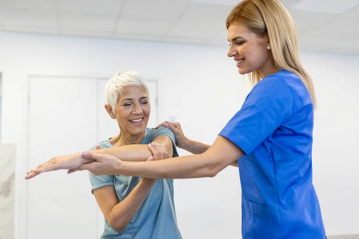 elbow pain senior woman exercise with physiotherapist