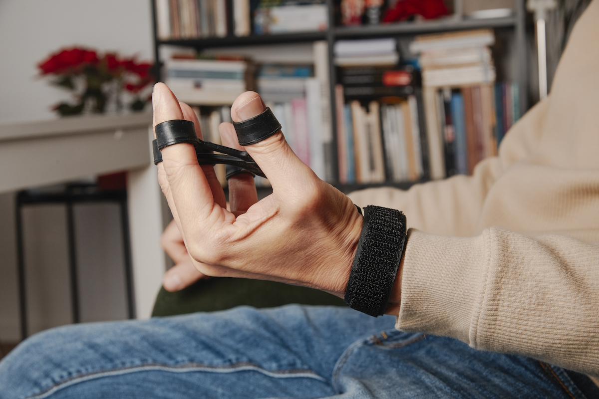 rheumatoid arthritis man stretches finger resistance trainer istock2269362857